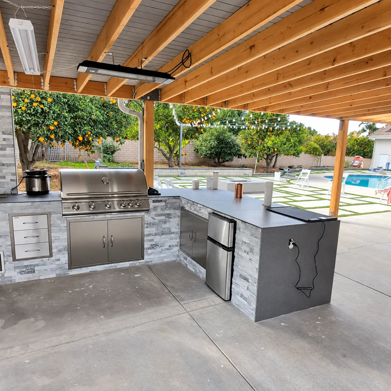 Outdoor kitchen construction with built-in grill and cabinetry
